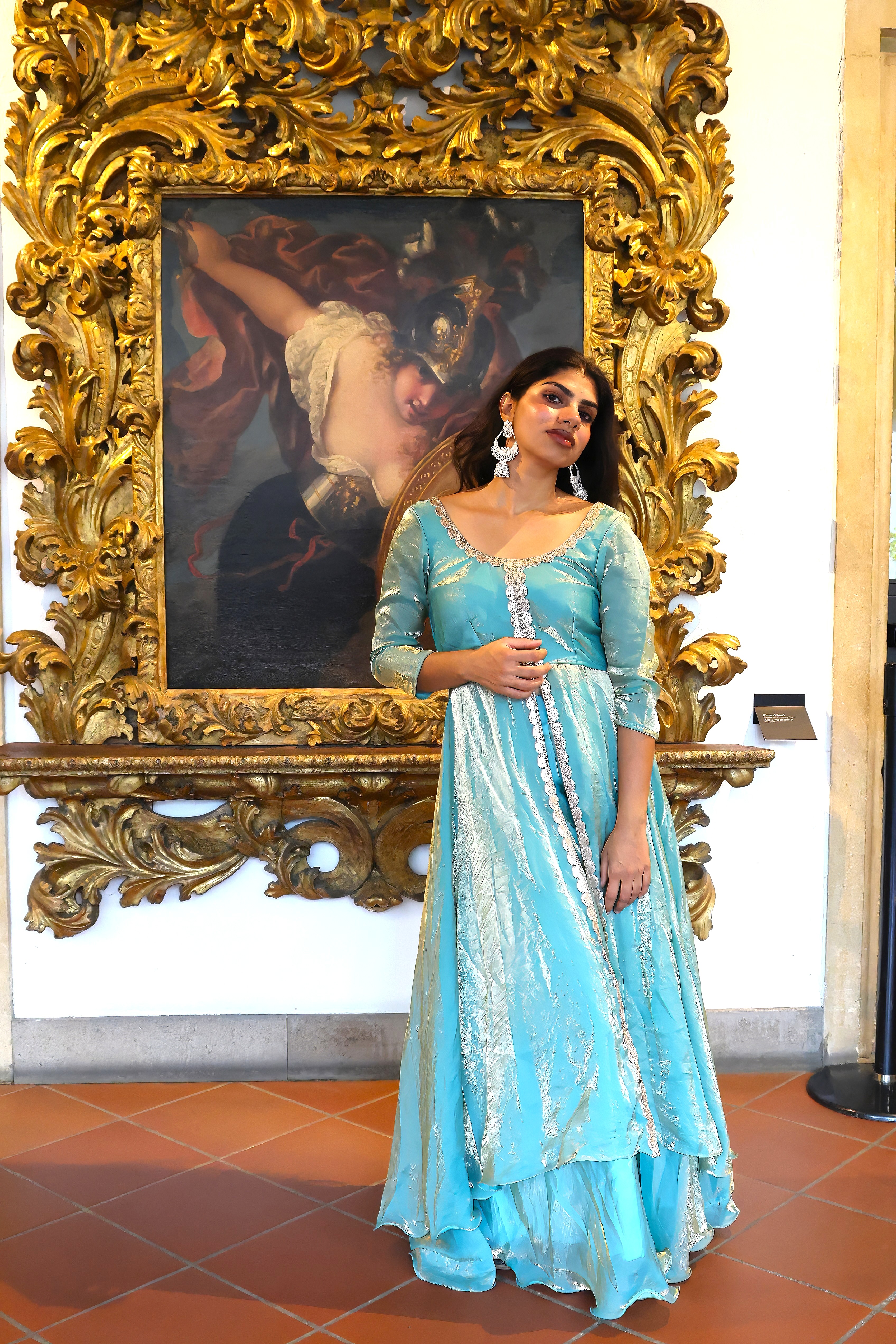 Vandana Meena in a turquoise Indian look inside an ornate Italian gallery