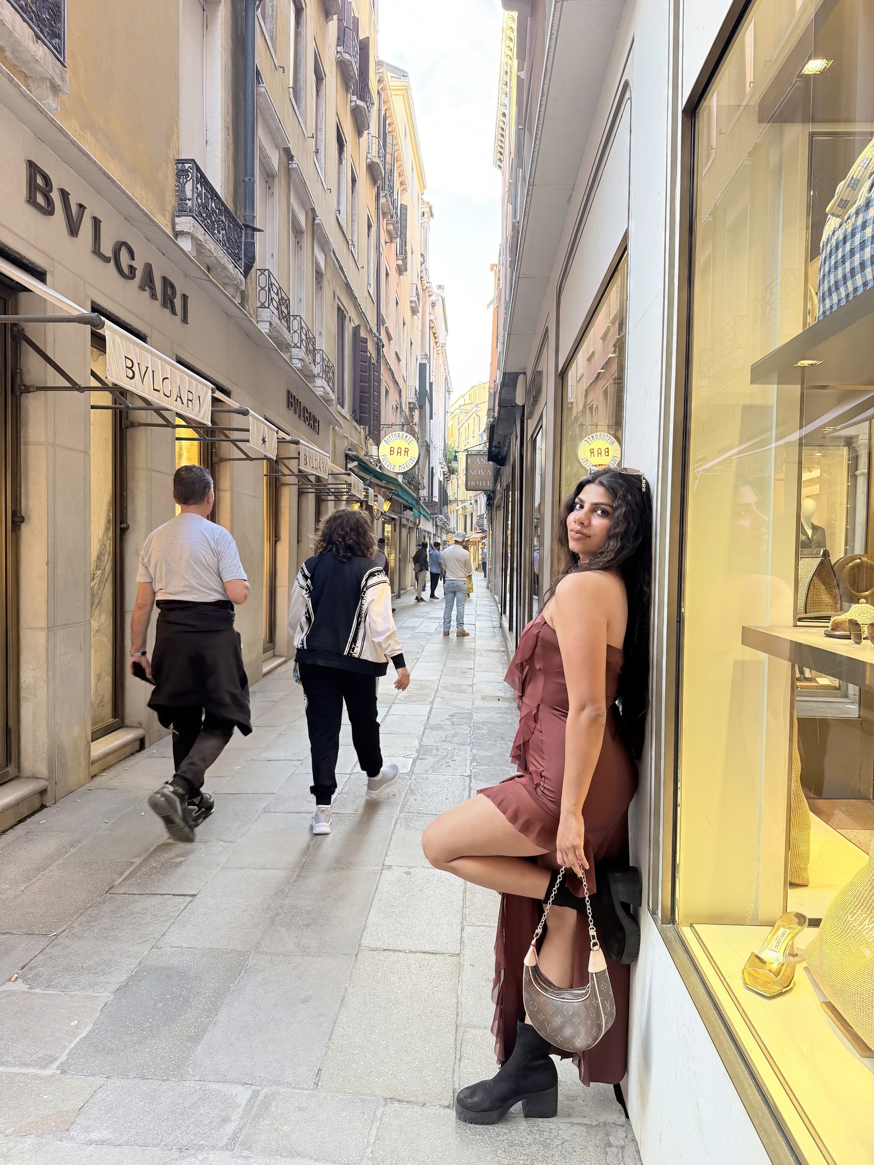 Vandana beside a luxury boutique and Venice canal